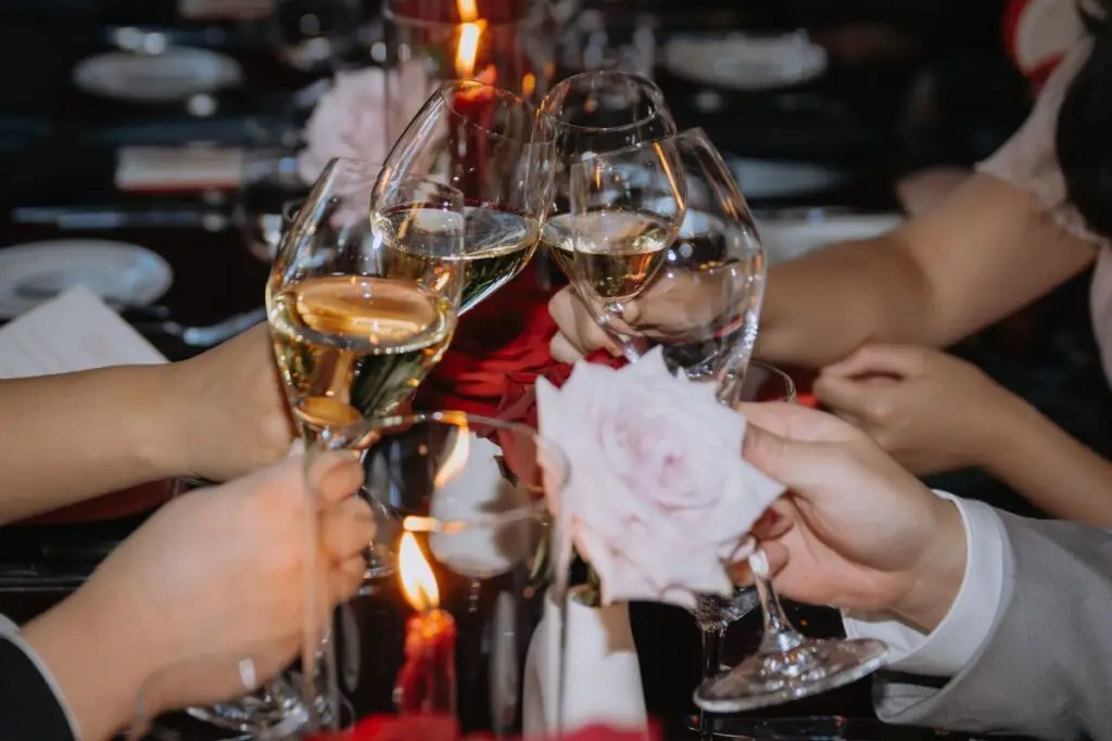 Wedding guests clinking wine glasses during a reception at Acquafarina in Vancouver