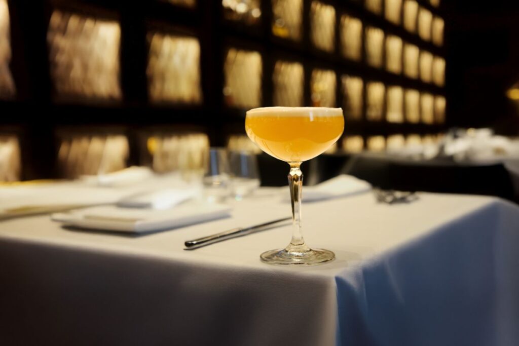 Signature cocktail served on a white table setting at Acquafarina in Vancouver