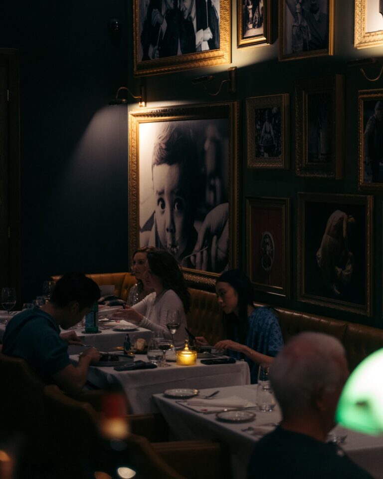 Private dining table beside Acquafarina’s portrait gallery wall in downtown Vancouver