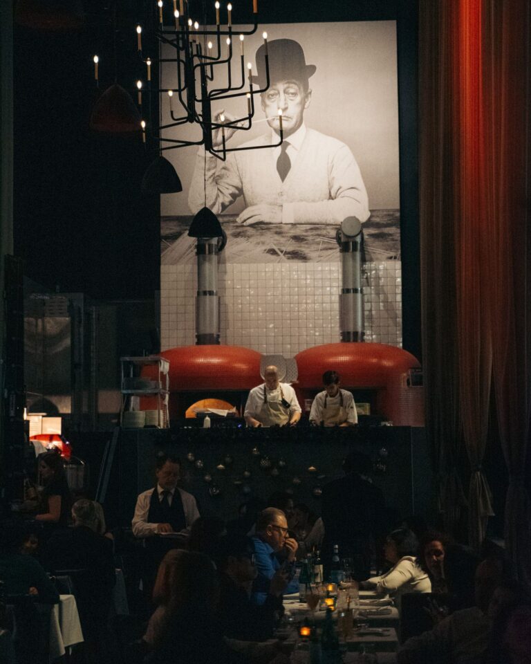 Elegant private dining area with red chairs and chandeliers at Acquafarina in Vancouver